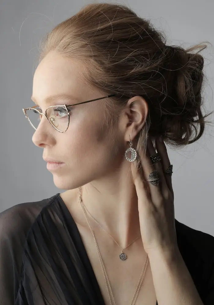 about-us Stylish portrait of a woman wearing glasses and elegant jewelry, exuding sophistication.