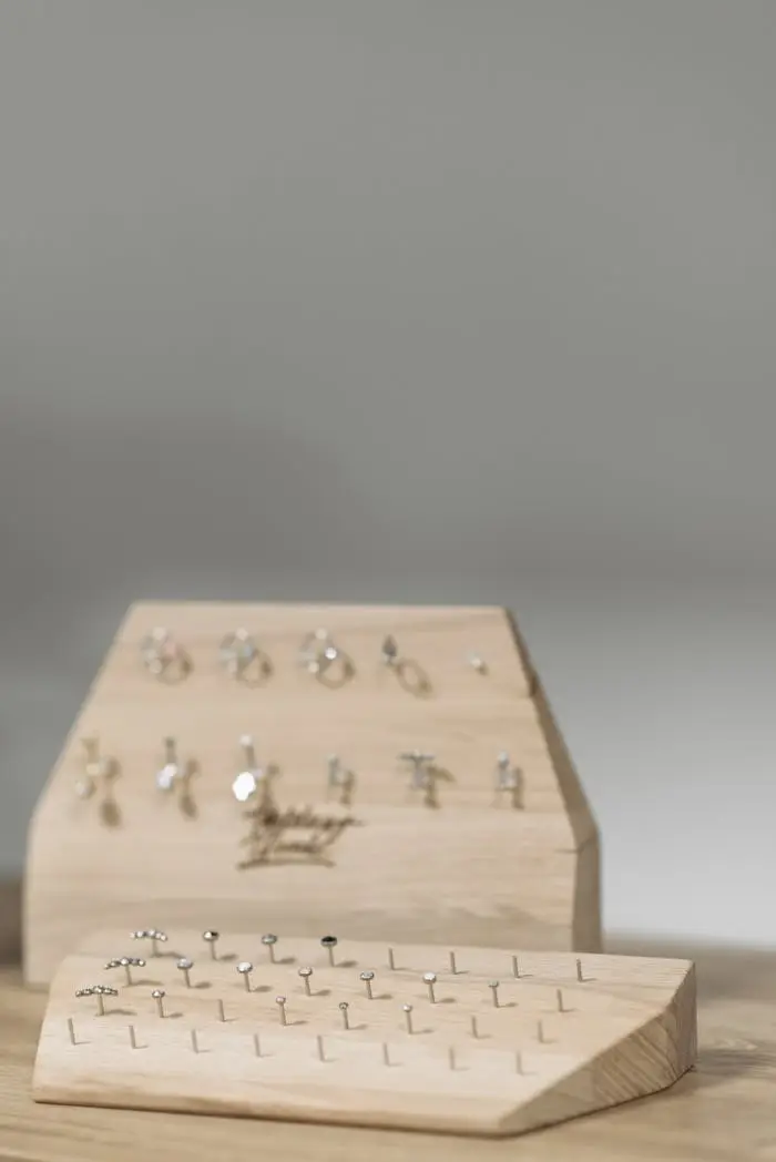 services-03 Showcase of elegant stud earrings on a wooden board with gray background.